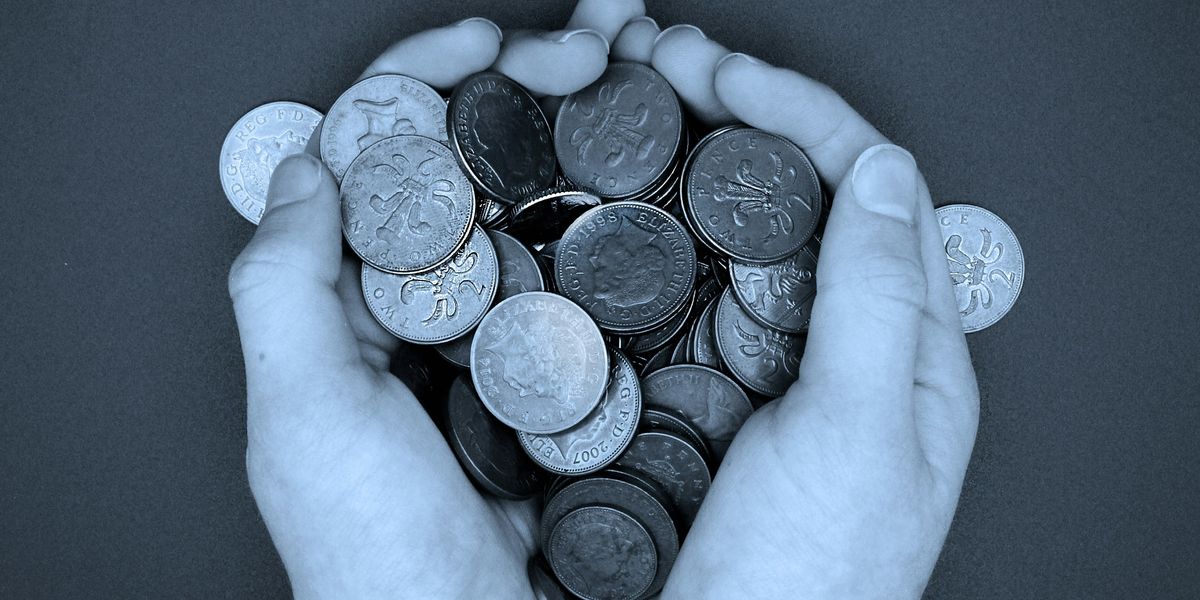A pair of hands holding a pile of coins
