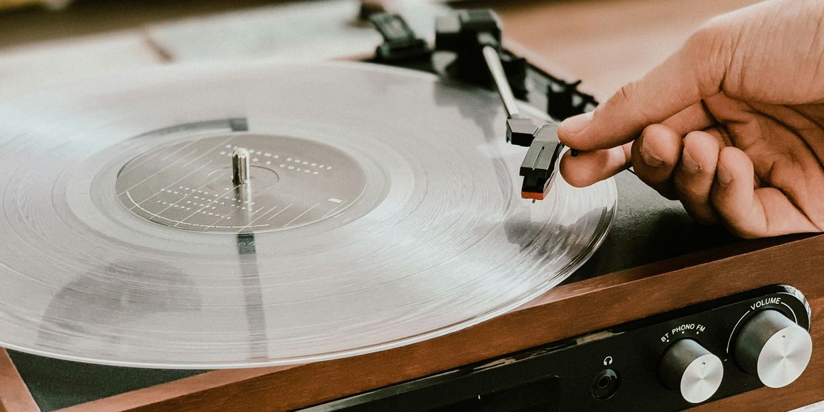 Person placing a needle onto spinning record